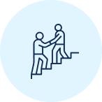 Two people assisting each other up a short staircase against a blue circle background, symbolizing teamwork and support.